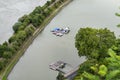 Motorboats attached to a jetty away from the river bank, top view.