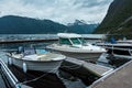 Motorboats, yachts, sailing and fishing boats moored to a pier in a small village in fjords Royalty Free Stock Photo