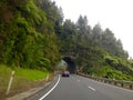 Motorcar driving on road tunnel carved out of rock mountain Royalty Free Stock Photo