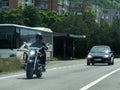 Motorcyclechopper and car in traffic. Road signs on the side of the road.