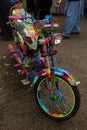 Motorcycle decorated in traditional Pakistani truck art, parked on a dirt sidewalk