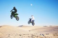 Motorcycle, desert and jump in sky, speed and competition at outdoor race for performance, goal or off road. Motorbike Royalty Free Stock Photo