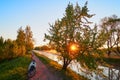 Motorcycle on a dirt road in a park at sunrise near flowering pear tree