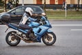 Motorcycle driver riding bike in the city street. Biker in helmet driving blue bike. Safety on the road Royalty Free Stock Photo