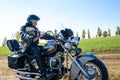 Motorcycle Driver Riding Custom Chopper Bike on Autumn Dirt Road in the Green Field. Adventure Concept. Royalty Free Stock Photo