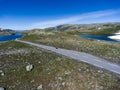 Motorcycle driving on asphalt road in Norwegian highlands. Snow road Aurlandsvegen is in Aurland, Norway