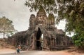 Motorcycle driving through the gate of Angkor with Buddha face, Great City of 12th century