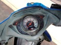 Motorcycle gauge display consist with velocity pointer and fuel oil on cement floor background closeup.