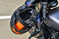 Motorcycle helmet hangs on handlebars of motorcycle. Protection when riding bike. Road safety for motorcyclists. black and orange Royalty Free Stock Photo