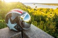 Motorcycle helmet with a mirrored visor on the background of nature