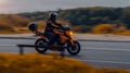 Motorcycle Kawasaki ER-6n in motion on the country road in evening. Side view of man riding motorbike at the background of autumn