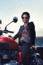 Motorcycle, leather and rebel woman in city with sunglasses for travel, transport or road trip. Fashion, evening and Royalty Free Stock Photo
