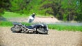 The motorcycle lies on the roadside, in the background the driver rides, slow-motion