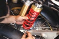 Motorcycle mechanic check and Change rear Shock Absorbers motorcycle, big scooter ,maintenance motorcycle concept in garage Royalty Free Stock Photo