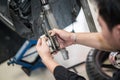 Motorcycle mechanic hands replace brakes in garage.  Worker changing brake disc. Brake disc installation concept Royalty Free Stock Photo