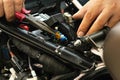 Motorcycle mechanic replaces a fuse battery. motorcycle maintenance and service and repair concept , selective focus