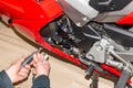 Motorcycle mechanic screwing on the fairing of a motorcycle - Serie Repair Workshop