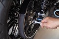 motorcycle mechanic use a wrench Adjust the belt pulley tension and drive belt on motorcycle working in garage .maintenance and Royalty Free Stock Photo