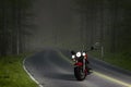 Motorcycle in the middle of an empty tree lined forest road. 3D rendering