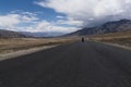 Motorcycle moving on a straight road in desert plains of Ladakh. Royalty Free Stock Photo