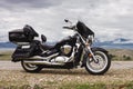 Motorcycle parked on a background of clouds and mountains