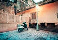 Motorcycle parked near lamppost in old city street