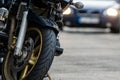 A motorcycle parked on the sidewalk with a defocused city street with cars in the background Royalty Free Stock Photo