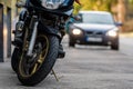 A motorcycle parked on the sidewalk with a defocused city street with cars in the background Royalty Free Stock Photo