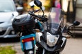 A motorcycle parked on the sidewalk with a defocused city street with cars in the background Royalty Free Stock Photo