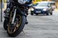 A motorcycle parked on the sidewalk with a defocused city street with cars in the background Royalty Free Stock Photo