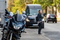 A motorcycle parked on the sidewalk with a defocused city street with cars in the background Royalty Free Stock Photo