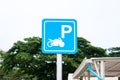 Metal motorcycle parking sign with tree background