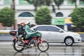 Motorcycle with passenger in the rain, Guangzhou, China