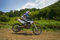 Motorcycle racer overcomes motocross track Royalty Free Stock Photo