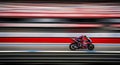 Motorcycle Racer Speeds Down Track with Motion Blur Effect Royalty Free Stock Photo