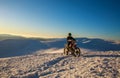 Motorcycle rider extreme sport biker on winter snowy mountains