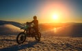 Motorcycle rider extreme sport biker on winter snowy mountains