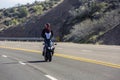 Motorcycle rider on a mountain road standing up on his bike Royalty Free Stock Photo