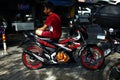 Motorcycle rider rests on his motorcycle while parked at a public parking lot