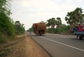 A motorcycle runs on National Highway 6 in Cambodia loading lots of rattan boxes