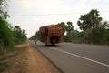 A motorcycle runs on National Highway 6 in Cambodia loading lots of rattan boxes