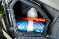 Motorcycle side compartment with container, tarp, and orange tools for travel essentials Royalty Free Stock Photo