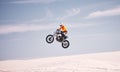 Motorcycle, sky and jump with a man in the desert riding a vehicle for adventure or adrenaline. Bike, speed and training