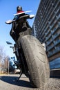 Motorcycle standing on stand on an urban street. City roadside, nobody, wide angle rear view Royalty Free Stock Photo