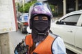 Motorcycle taxi man wearing helmet and cloth mask in Bangkok, Thailand