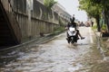 Motorcycle Taxis and volunteer carrying people passed flood on the road go to Bang pai temple