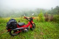 Motorcycle touring parked on a mountain lawn in rain and fog in Thailand