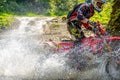 Motorcycle in Water Spray and Athlete Enduro