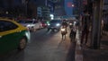 Motorcycles overtake taxicab on the traffic during rush hour at night in the street of Bangkok, Thailand. - close up