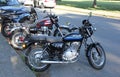 motorcycles parked on the curb near a parking lot in a city Royalty Free Stock Photo